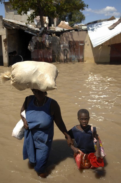 Kovan onnen Haiti! Tässä haitilaisäiti on saanut ruoka-apua 2008 hurrikaanin jälkeisissä tulvissa. 2010 saari kohtasi valtaisan humanitäärisen kriisin, kun maanjäristys runteli sitä. Jälleenrakennus on edelleen kesken, ja nyt trooppinen hirmumyrsky Matthew teki pahaa tuhoa saarivaltiossa.